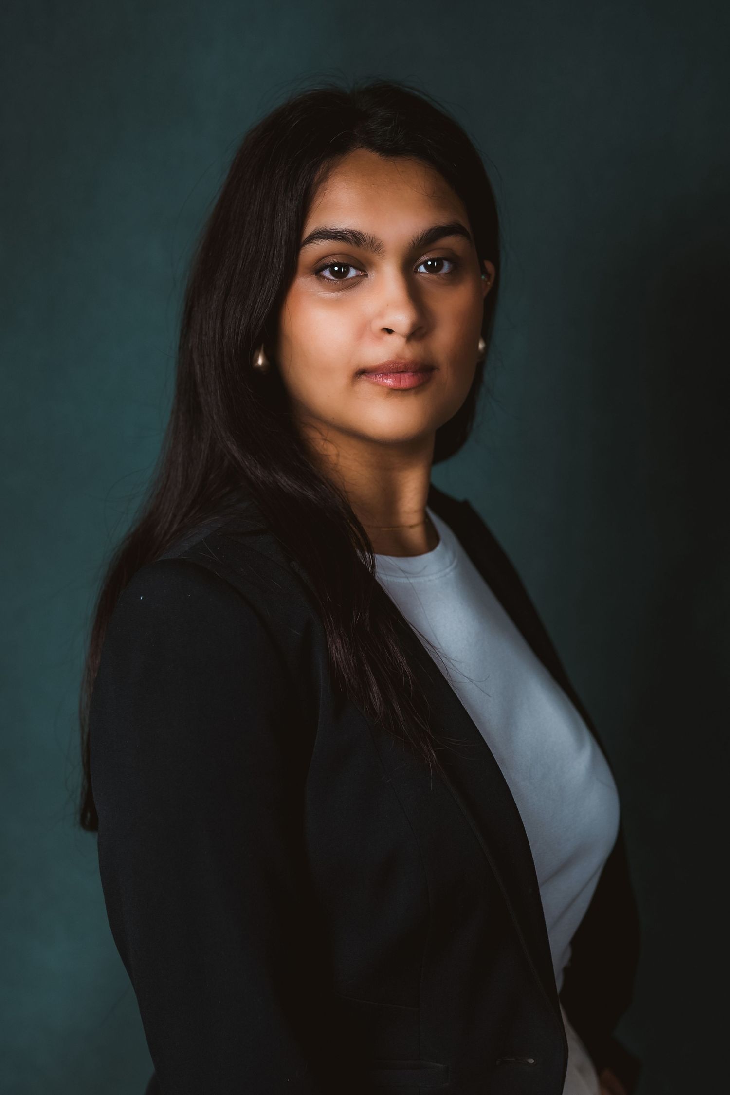 Corporate headshot in Dubai – professional woman in black blazer, dark studio background