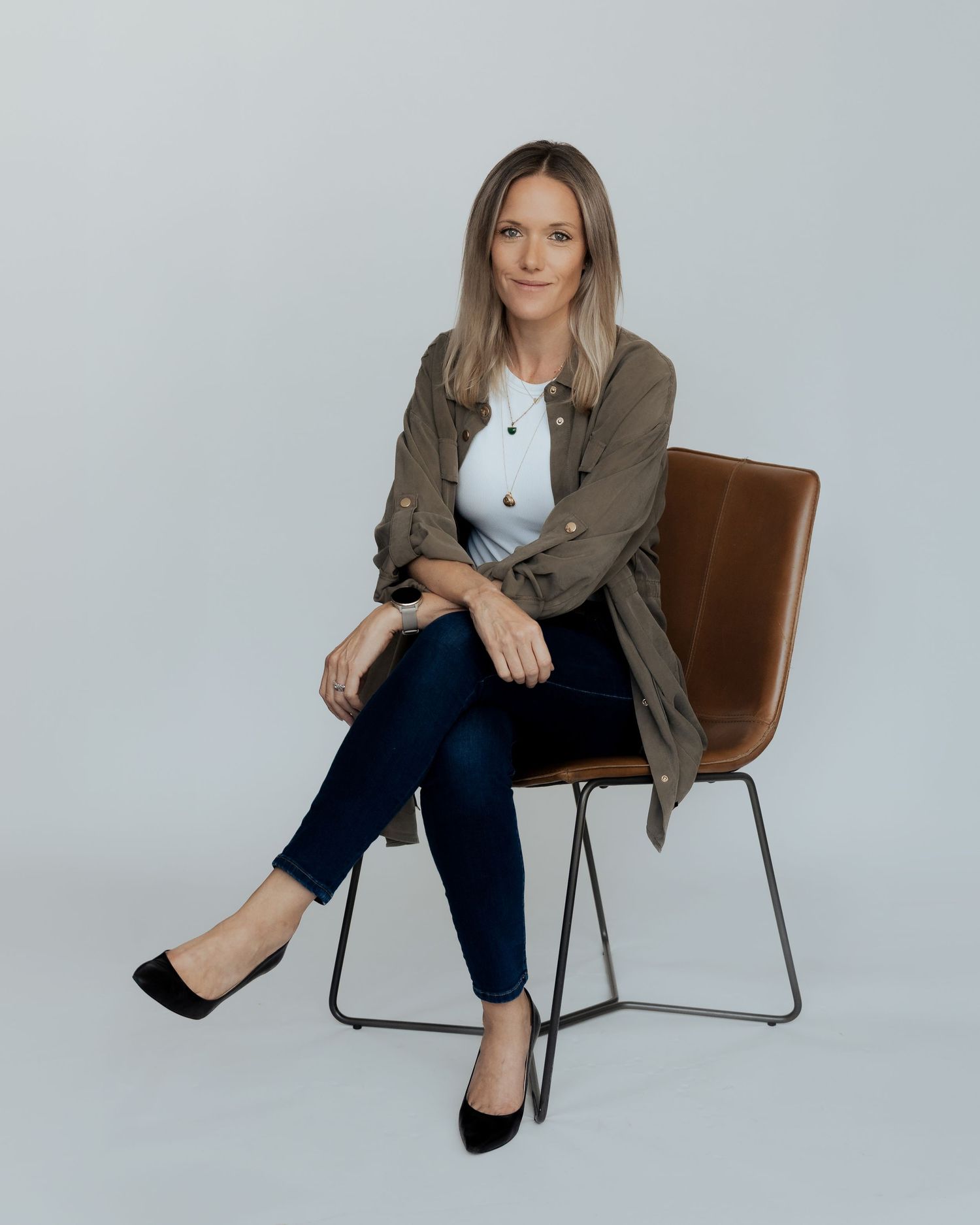 Corporate headshot in Dubai – professional woman seated on chair, studio portrait