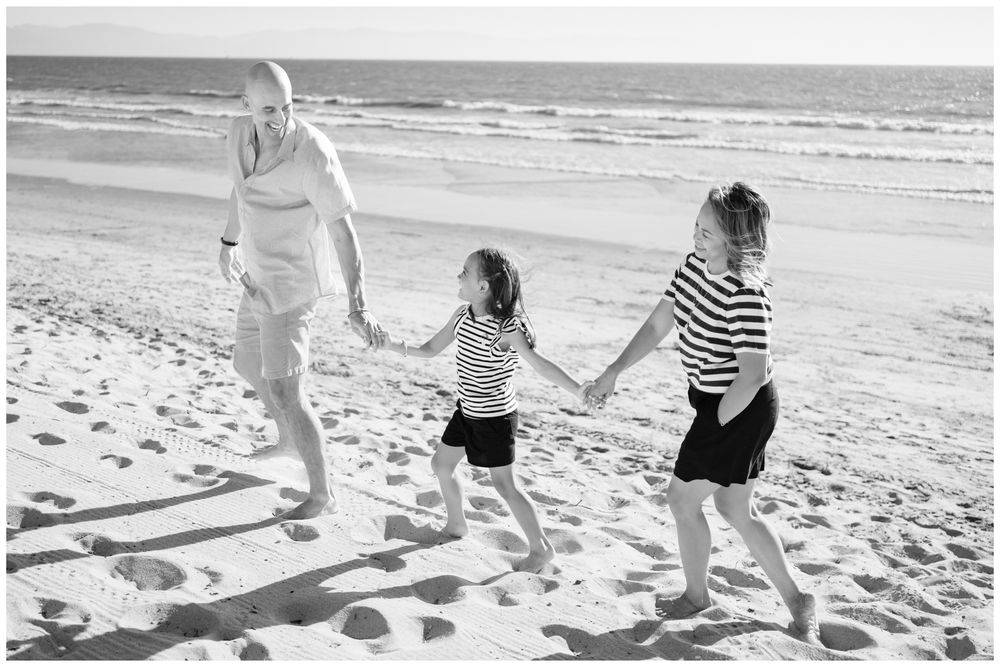 Black and white family portrait walking along the beach in Punta Mita.