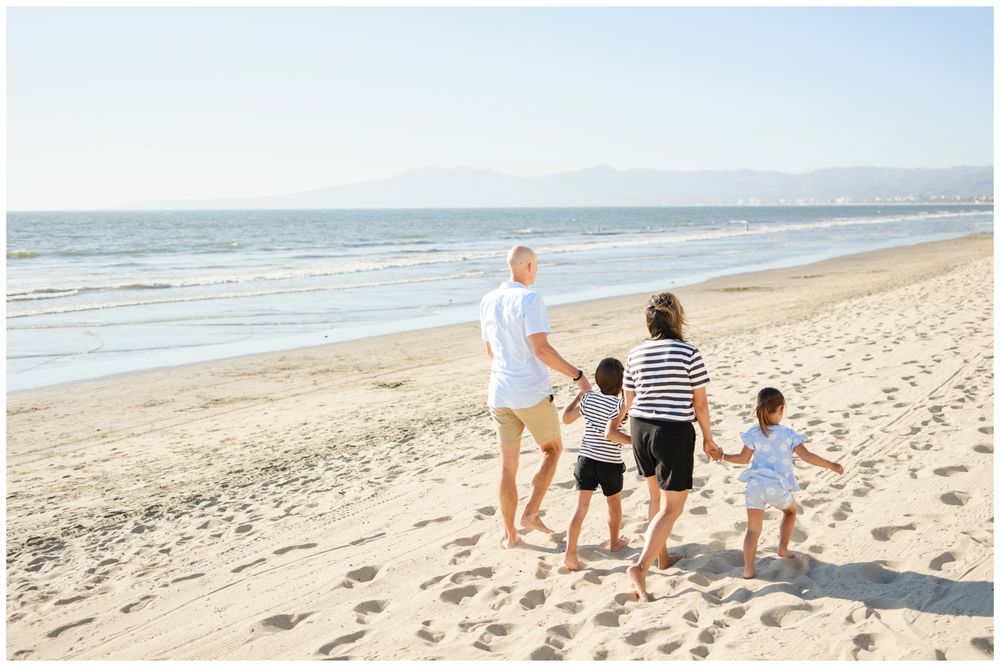 Family walking along the shoreline during a beach session in Punta Mita.