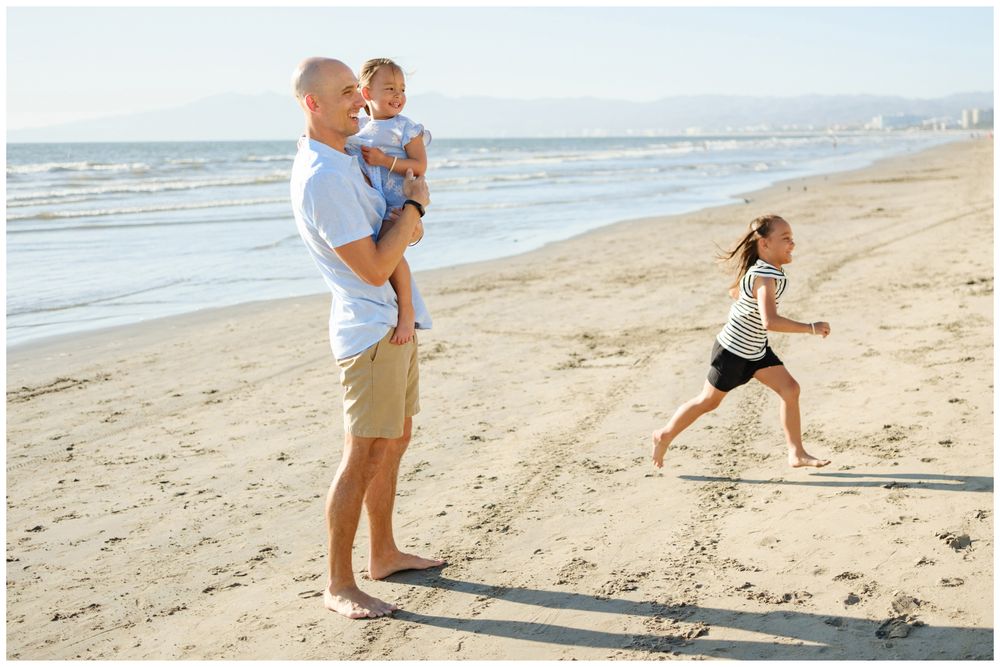 Father holding his daughter while the family plays during a beach session in Sayulita.