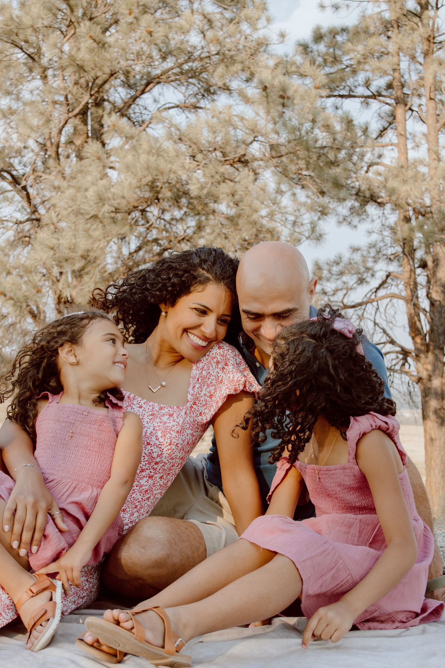 Large family group portrait taken outdoors against mountain landscape backdrop.