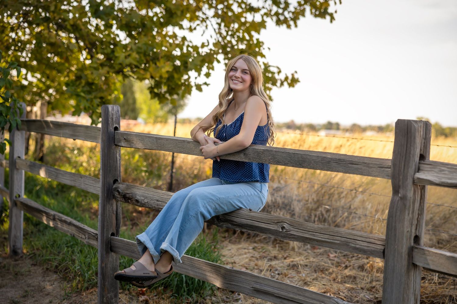 girls sitting on wood fence