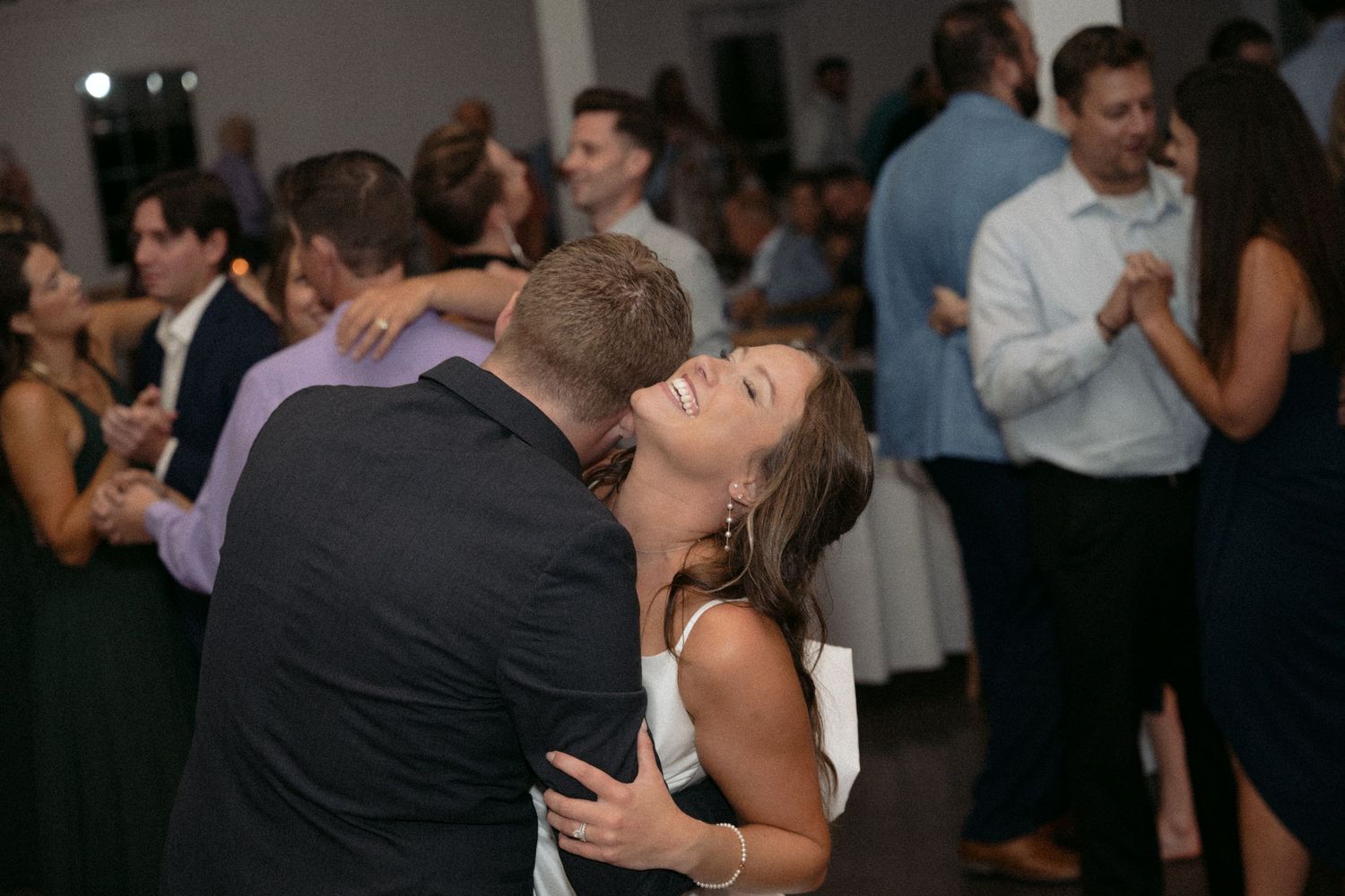Bride and groom hold each other and dance the night away surrounded by all their friends and family at Abella in Chisago City, MN.