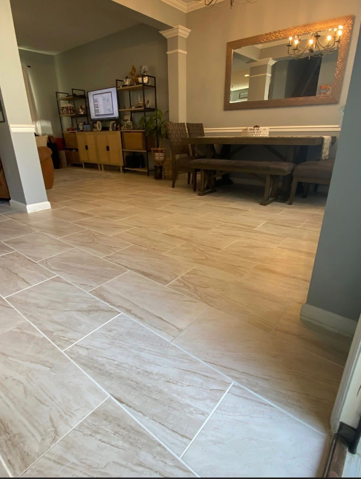 Large format light beige porcelain floor tiles in open concept dining and living room area.