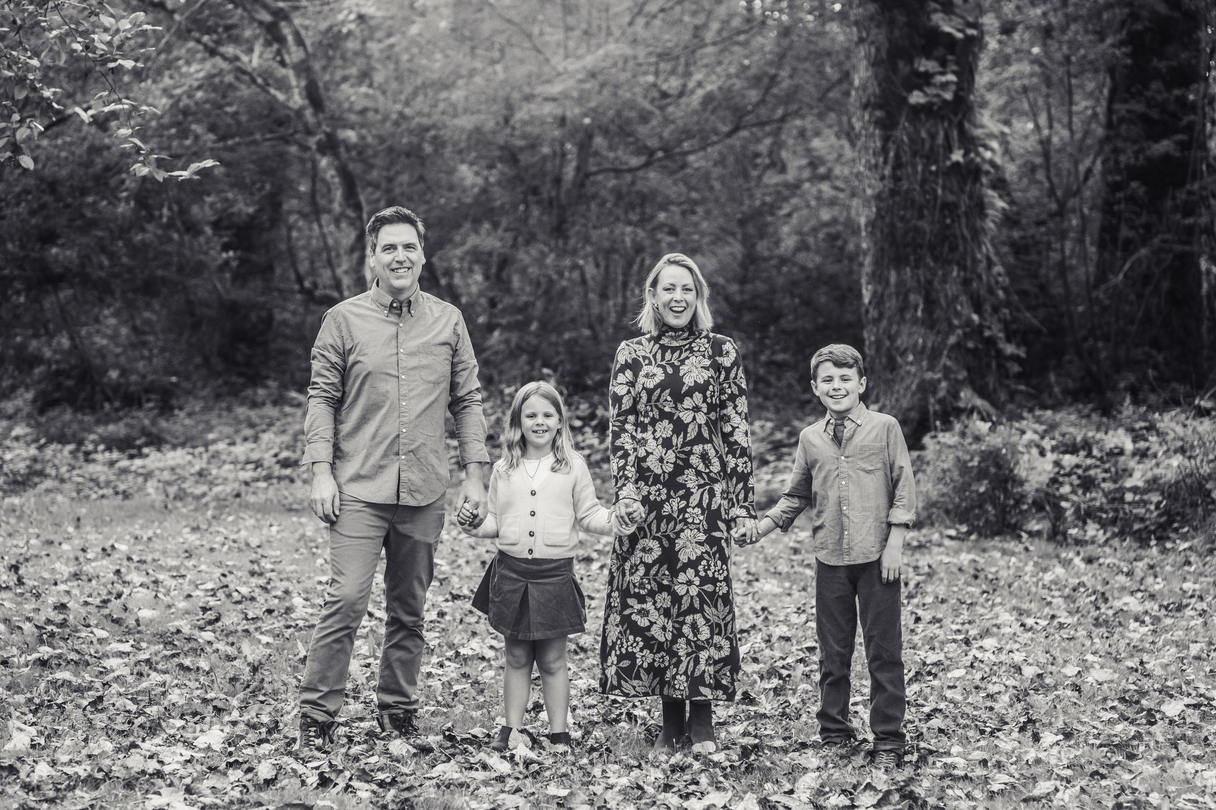 Black and white photo of family posed and smiling in the forest in North Bend.