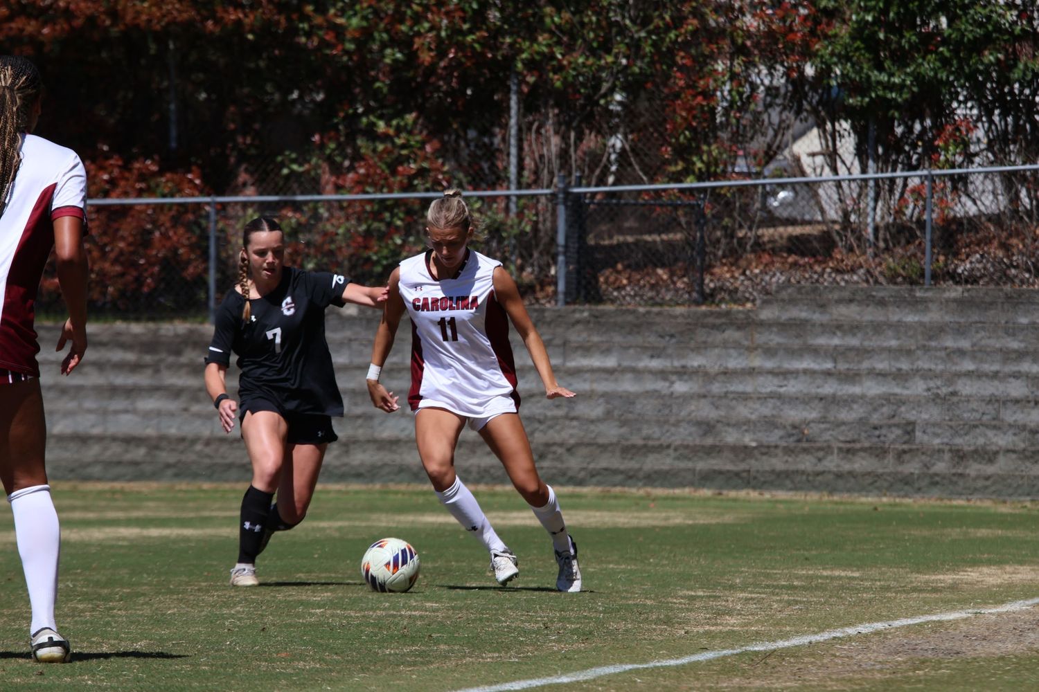 South Carolina women's soccer player dribbles the ball while a defender closes in.