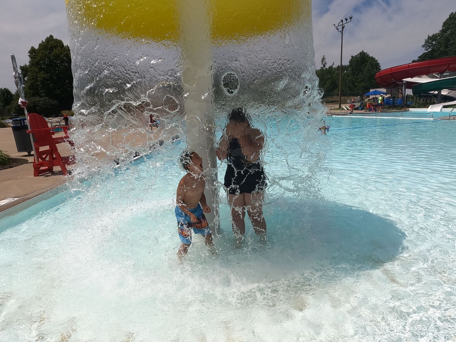 Children playing together in a swimming pool during a family vacation.