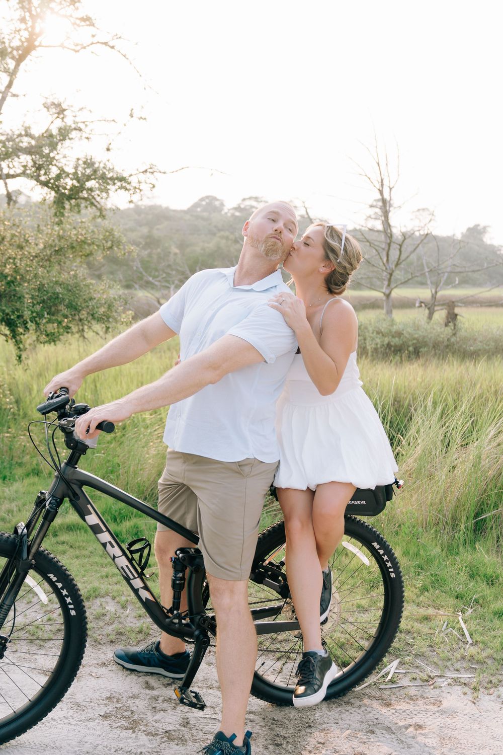 Rachel and Bo with their bikes during their engagement session at Driftwood Beach on Jekyll Island