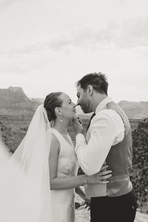 Black and white photo of a bride and groom sharing an intimate moment at the Grand Canyon on their wedding day.