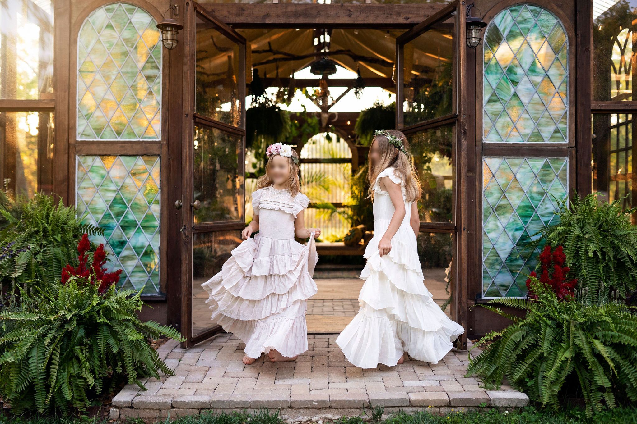Two girls in flowing floral dresses during a Middle Tennessee golden-hour boho session at a greenhouse.