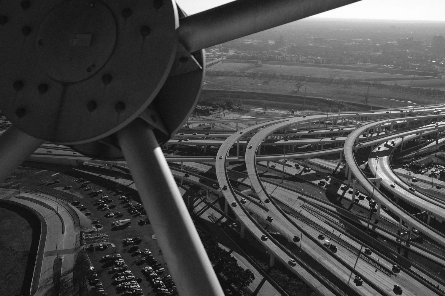Black and white aerial view of complex highway interchange with curving ramps, shot from Atomium structure in Brussels.