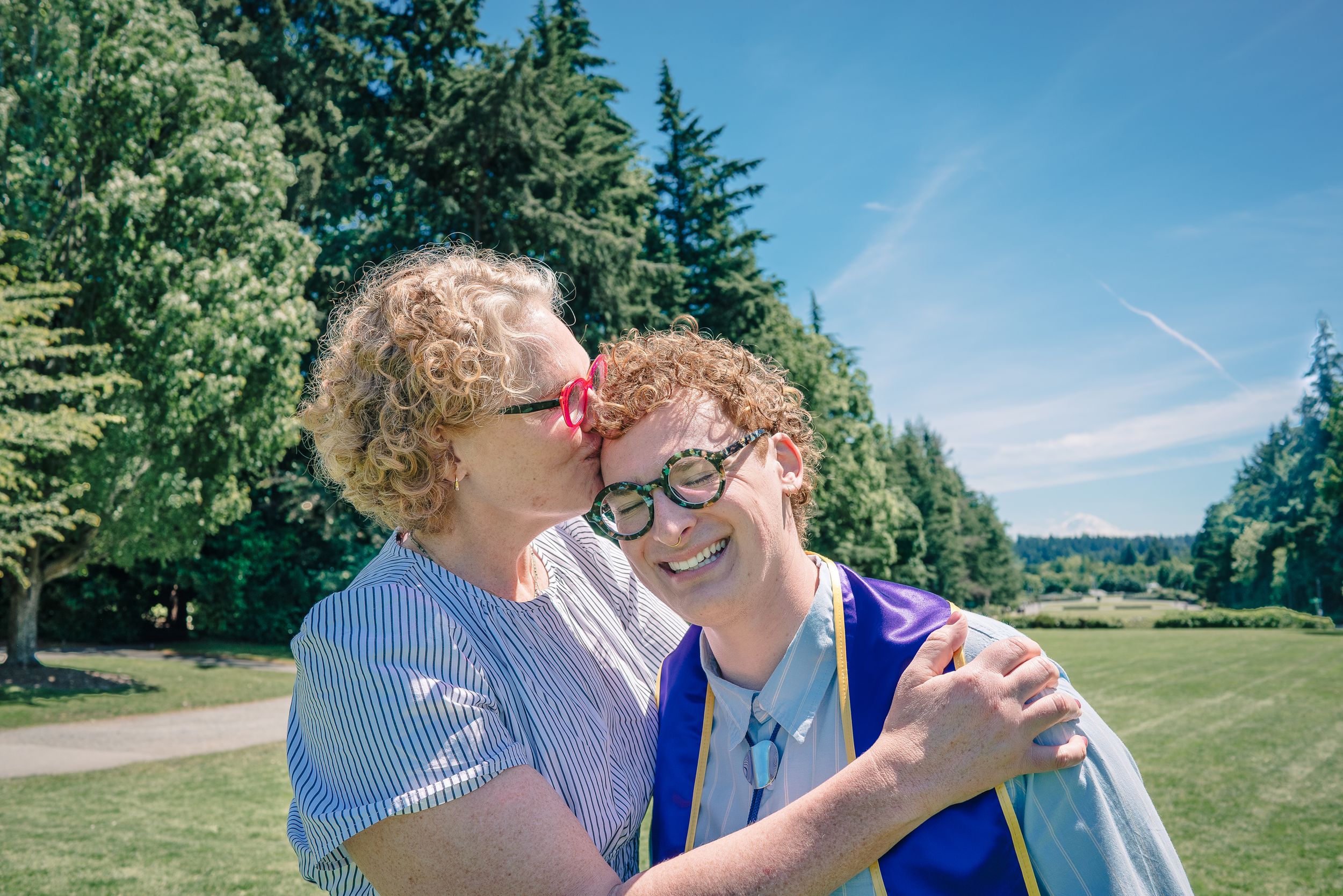 Graduate sharing a candid moment with family during University of Washington graduation session. Mother and son photography.