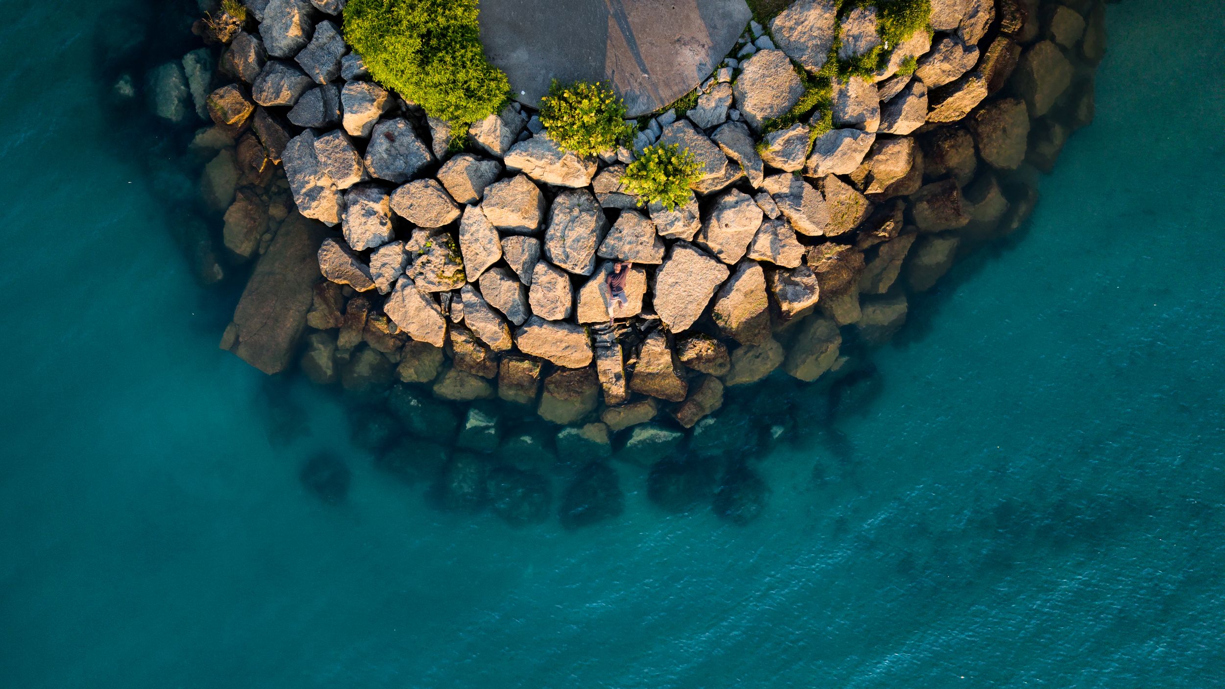 Aerial view of a rocky point over turquoise water