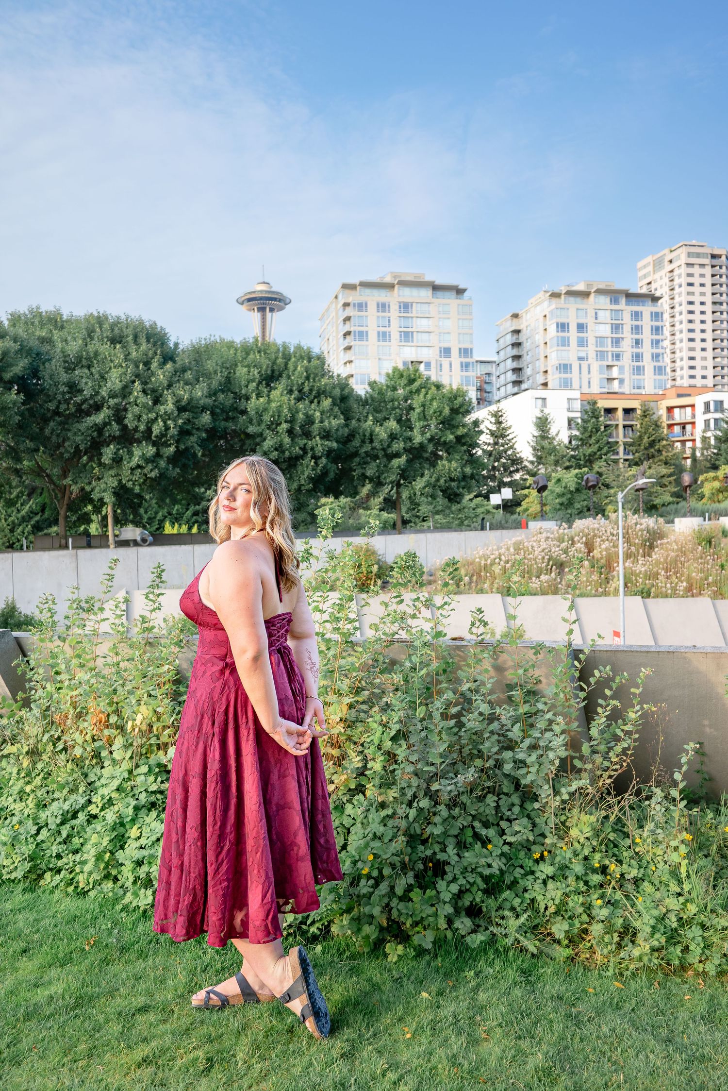 High school senior posing at Olympic Sculpture Park with the Space Needle visible behind her