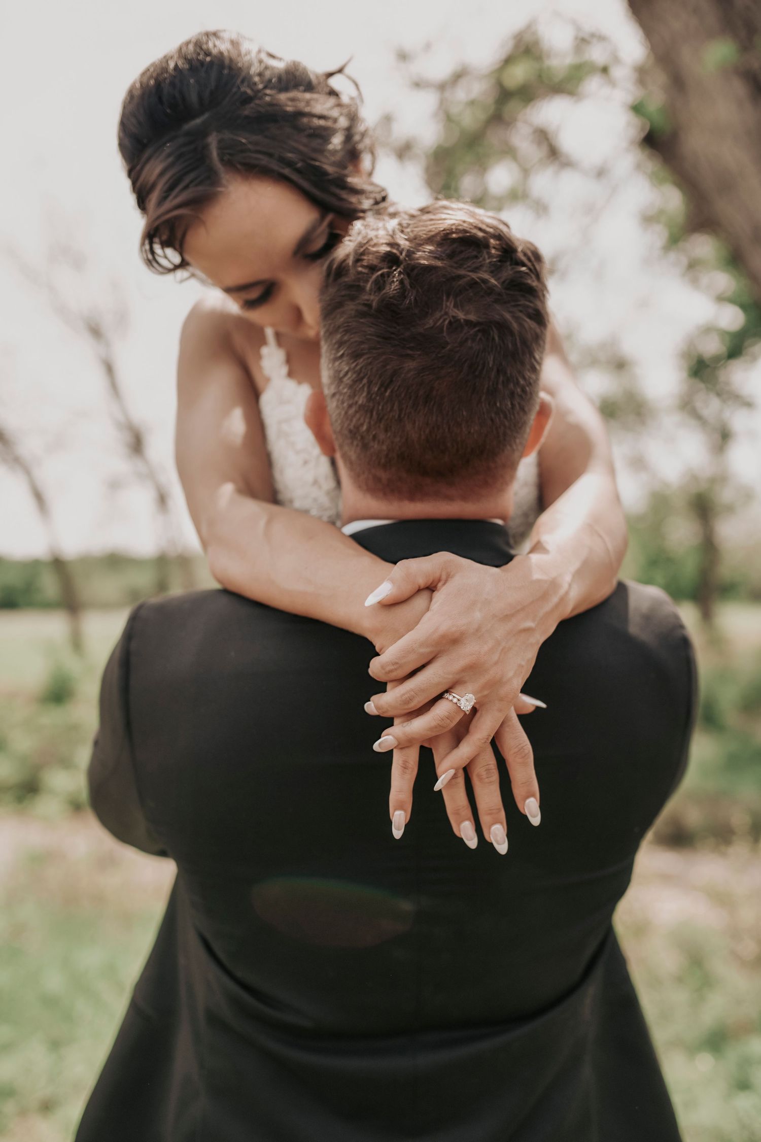 a bride is lifted by her groom for a close up of her ring