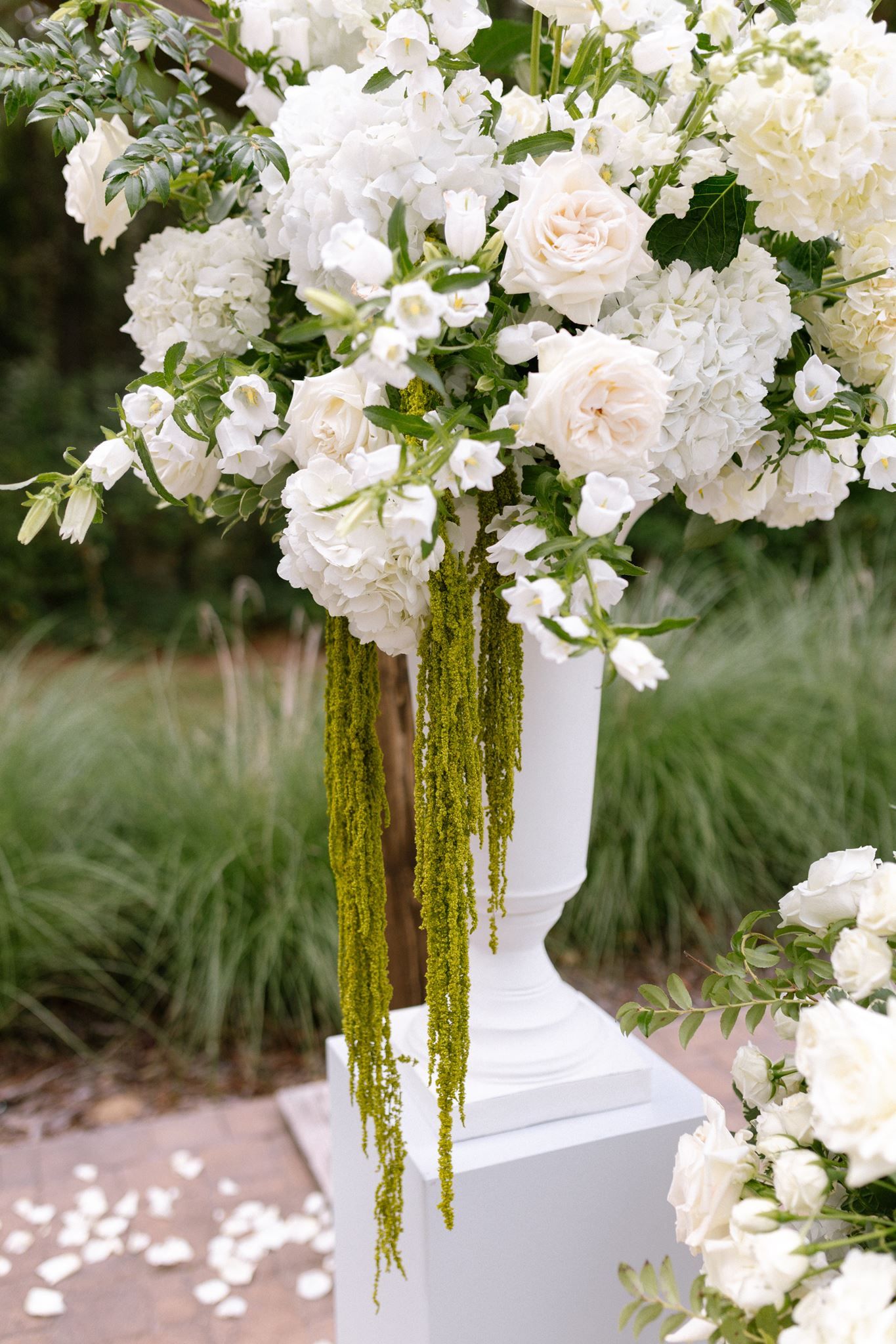 Lush white floral pillar for ceremony at Historic Hill House in Willis Texas.