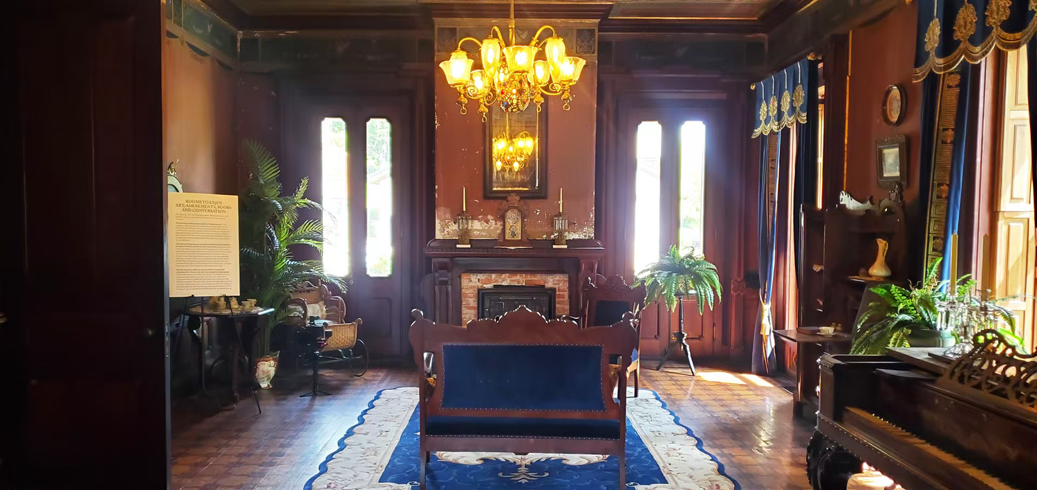Elegant Victorian parlor with chandelier, fireplace, blue rug at mac-o-chee wedding venue castle