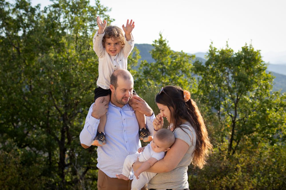 Famille dans la nature : enfant sur les épaules de son père, maman portant le bébé, Ardèche