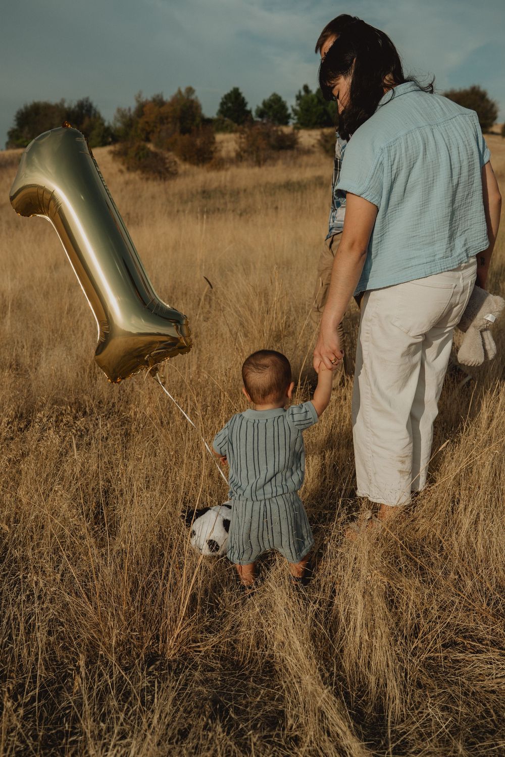 Mom walking hand-in-hand with her baby during a first birthday family session in Pullman, Washington.