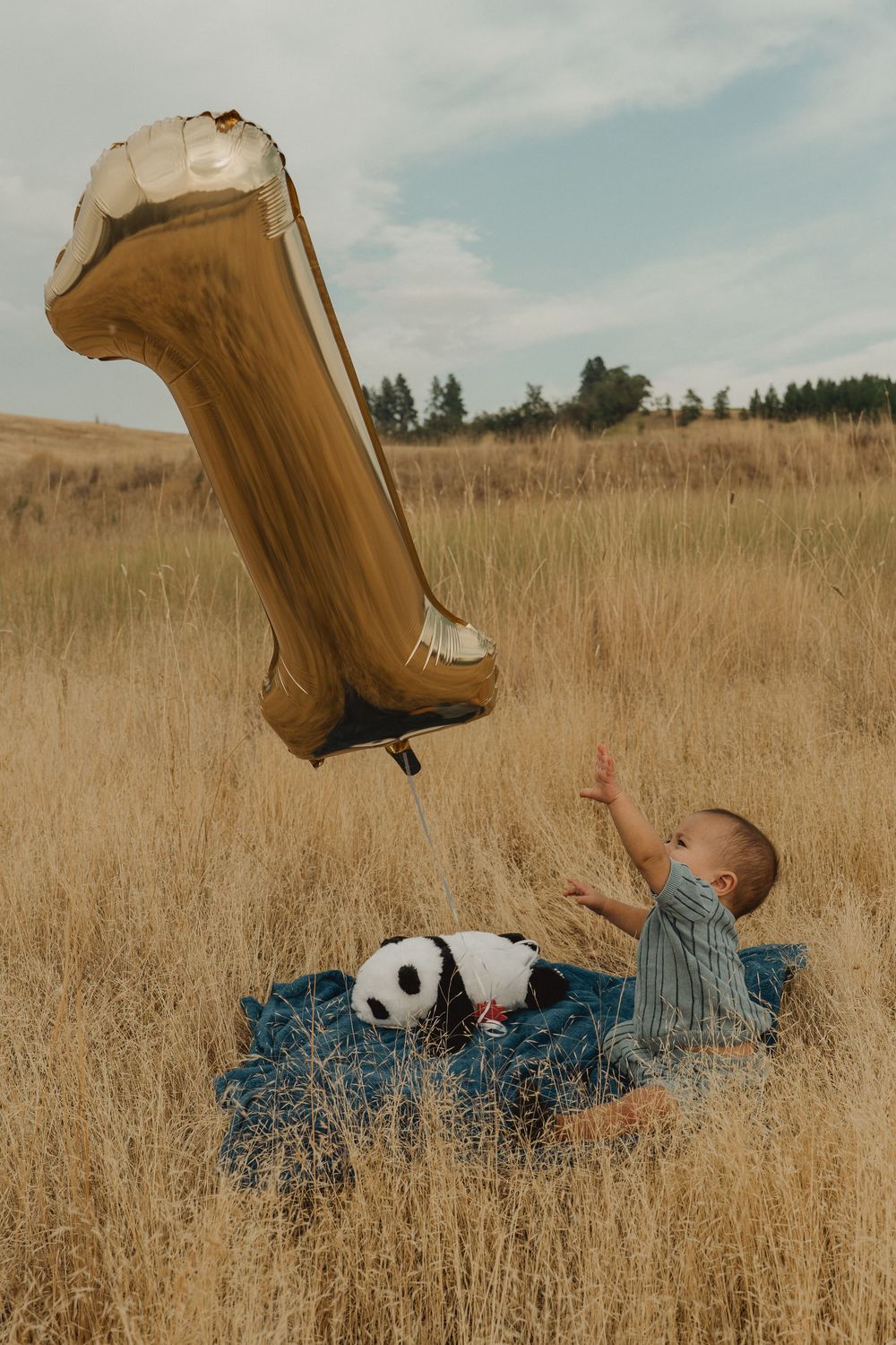 One-year-old baby with a birthday balloon during a first birthday photography session.