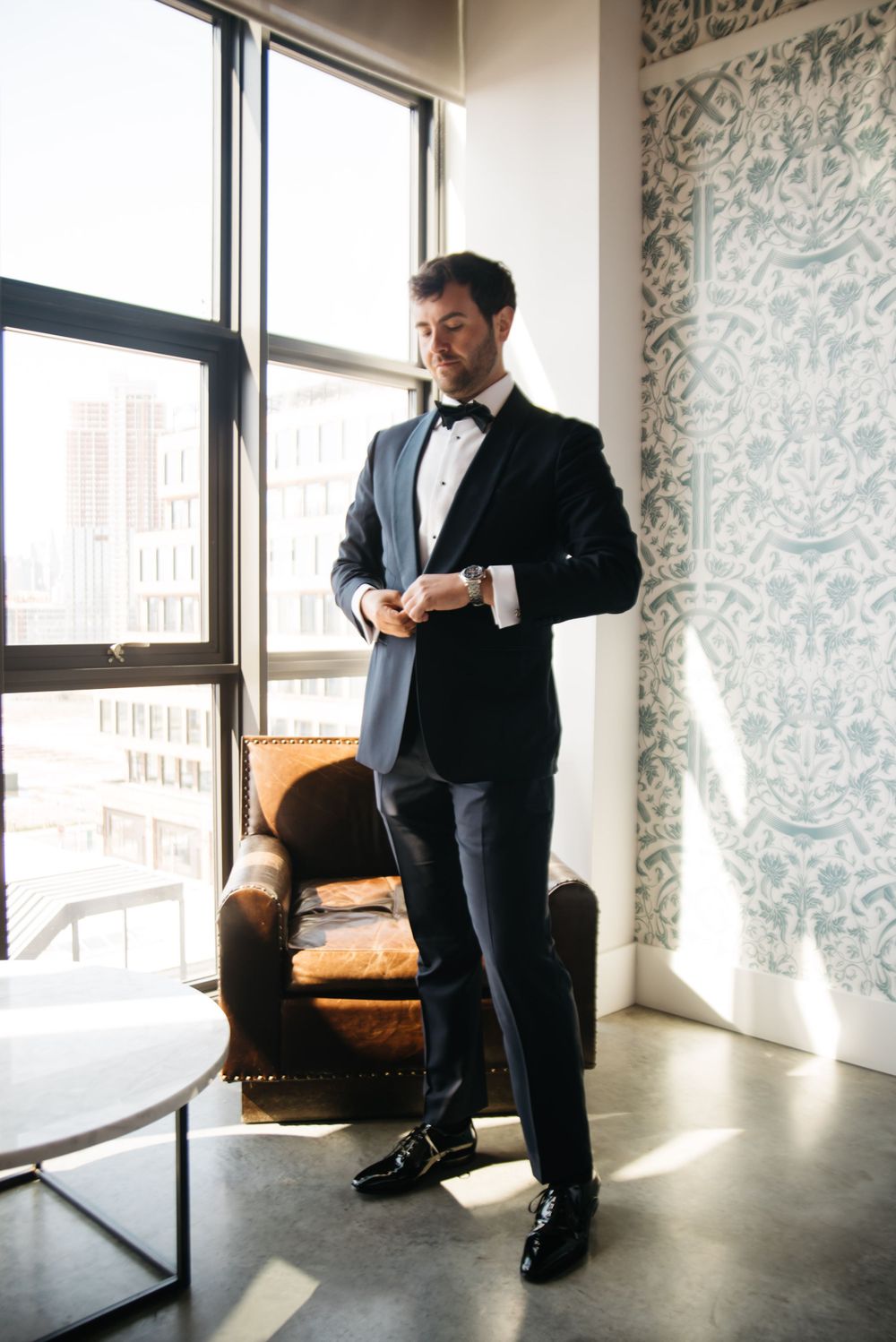 Classic formal attire showcased in modern interior setting with window lighting.
