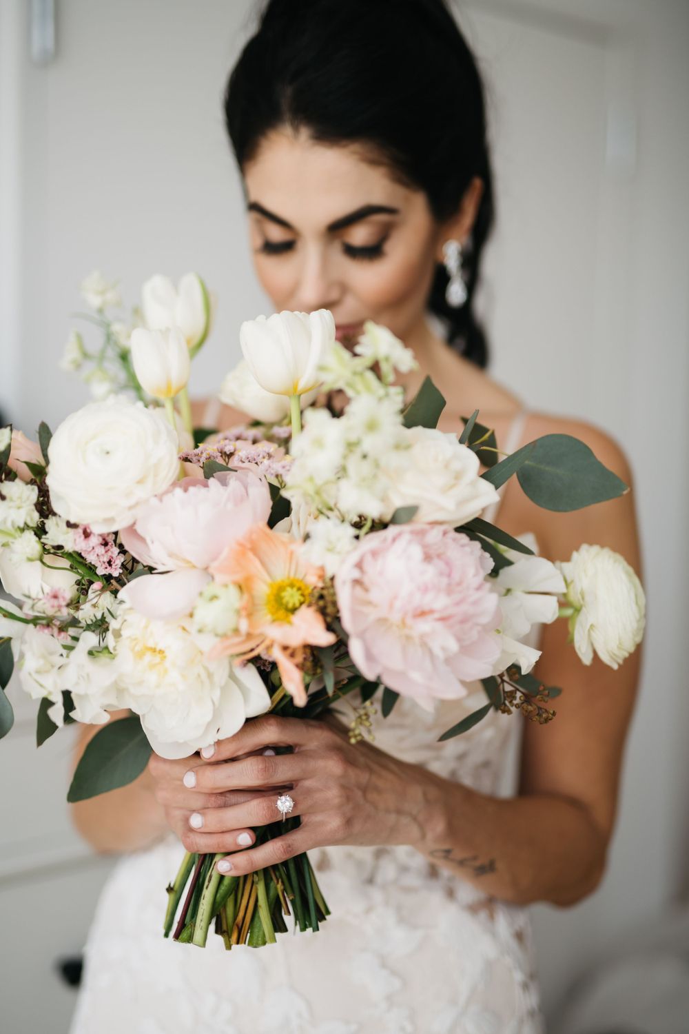 Romantic bridal portrait with a lush bouquet of pink and white garden roses and greenery.