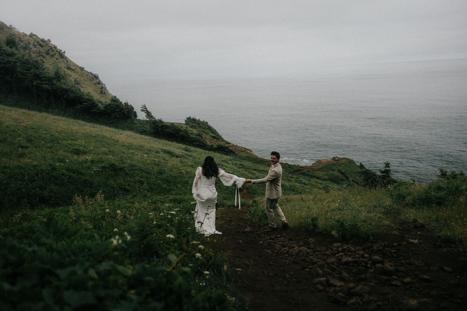 A series of romantic wedding photos captured on a misty coastal cliff with moody overcast skies and dramatic landscapes.