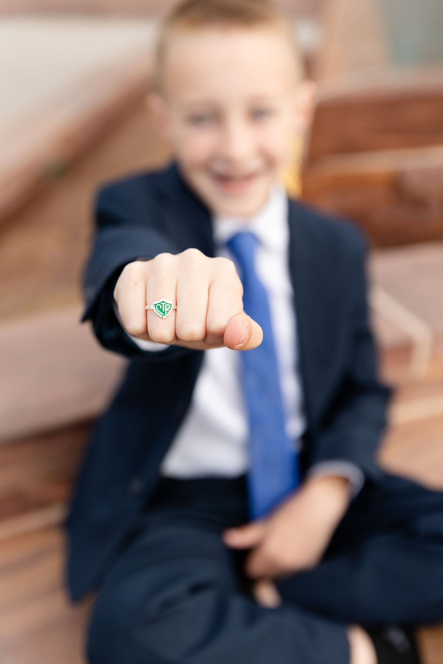 a boy holding out his fist showing a ring that says CTR, church of Jesus Christ of Latter Day Saints