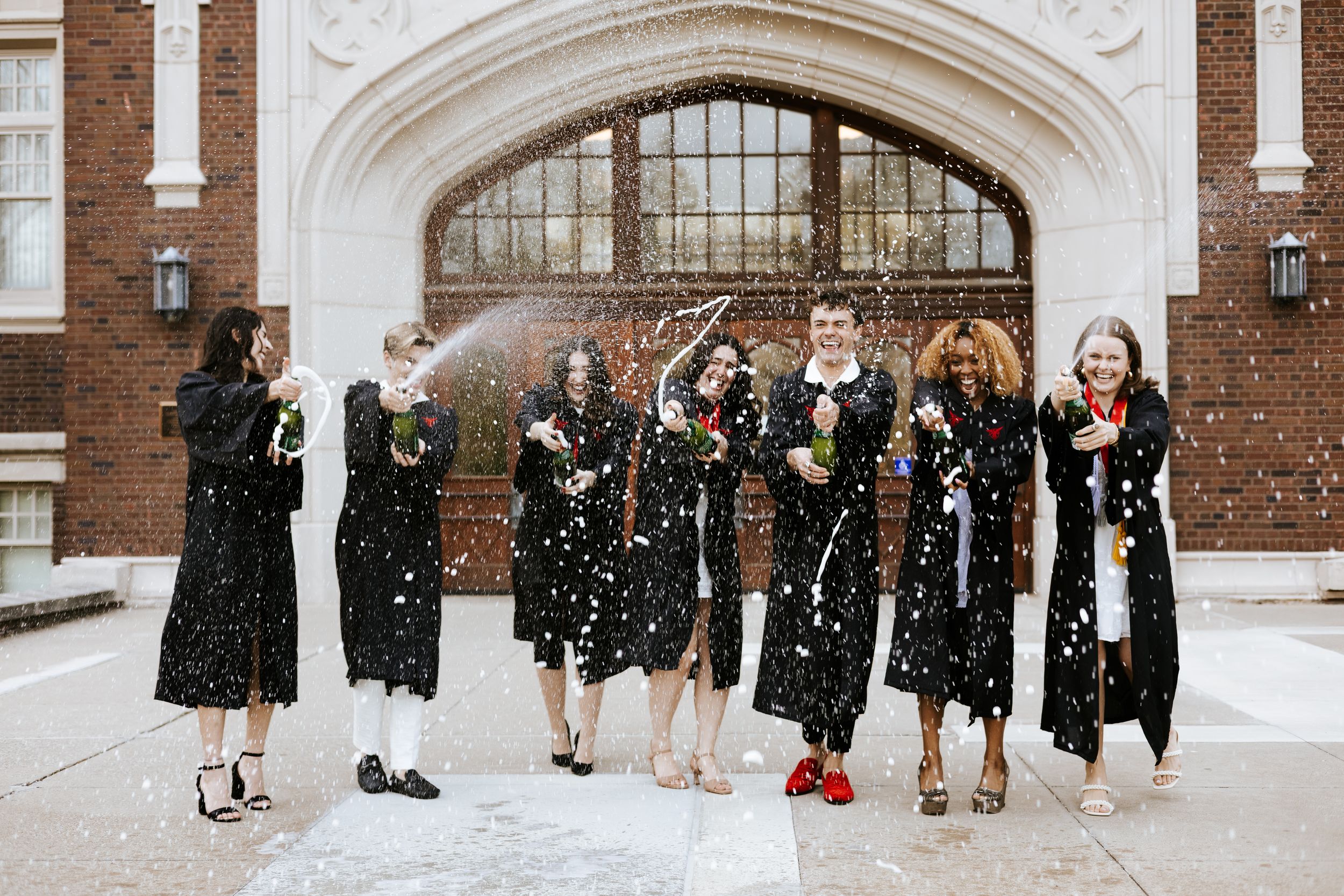 Group photo showing shoes and legs in front of historic brick building entrance.