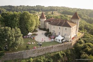 Aerial view of a historic chateau venue surrounded by lush countryside.