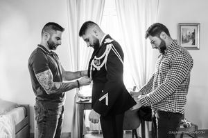 Three people getting ready in a bright room during wedding preparations.