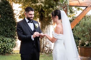Romantic wedding ring exchange sequence in an outdoor garden setting.