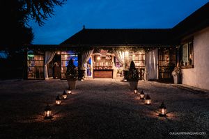 Silhouetted buildings and trees at dusk with ambient lighting at a wedding venue.