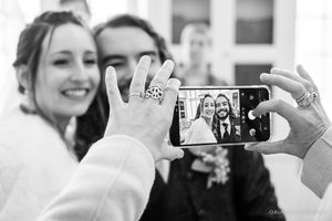 Wedding guests capturing celebratory moments on their smartphones.