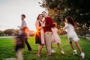 A group dances together in a park at sunset with motion blur creating a dreamy atmosphere.