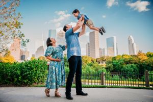 A family enjoys quality time together at a scenic park with the Houston city skyline rising in the background.