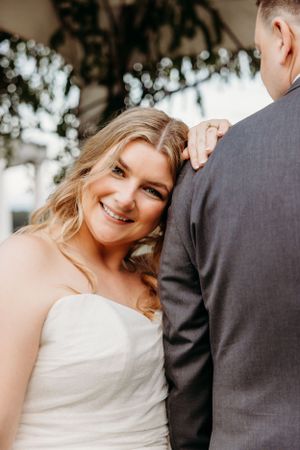 Candid wedding moment captured under floral arch with natural lighting.