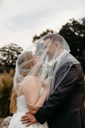 A romantic wedding moment with the couple sharing a kiss under a flowing veil.