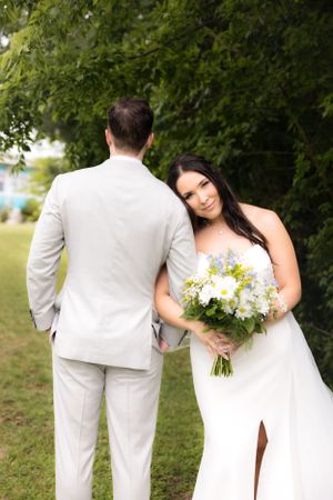 Intimate outdoor wedding portrait with bride holding white and yellow bouquet.