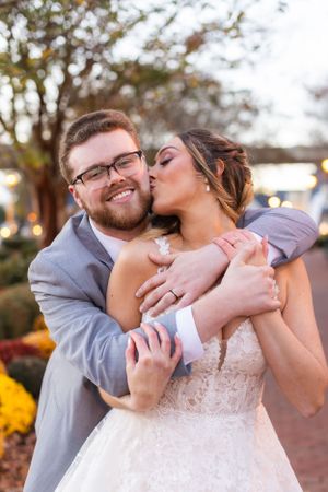An intimate moment between newlyweds sharing laughter in an outdoor setting.