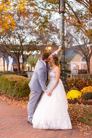 A tender moment between newlyweds on a brick path surrounded by fall foliage.