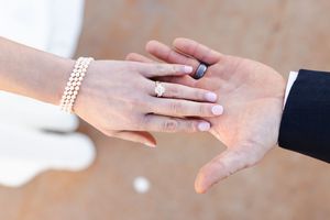 Close-up view of hands exchanging a wedding ring during a marriage ceremony.