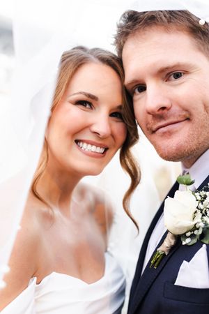 Close-up wedding portraits showing romantic moments between a couple in formal attire with white floral boutonniere.