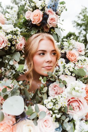 Beautiful floral crown made of pink roses and eucalyptus leaves creates a romantic bridal look.