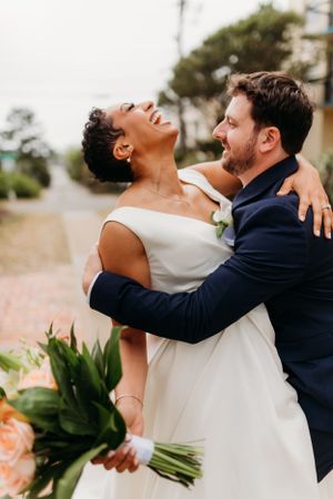 Newlyweds share intimate moment during outdoor wedding photoshoot.