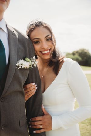 Candid wedding portrait showing joyful smile and elegant bridal details.