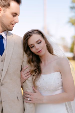 Newlyweds embrace in soft natural light during intimate wedding portrait session.