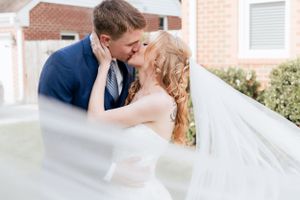 Romantic wedding couple sharing intimate moment under flowing veil.