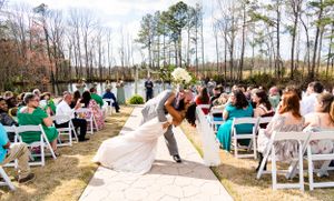 Wedding guests watch couple's romantic dip during outdoor ceremony with turquoise decor.